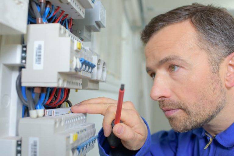 Electrician inspecting fuse box