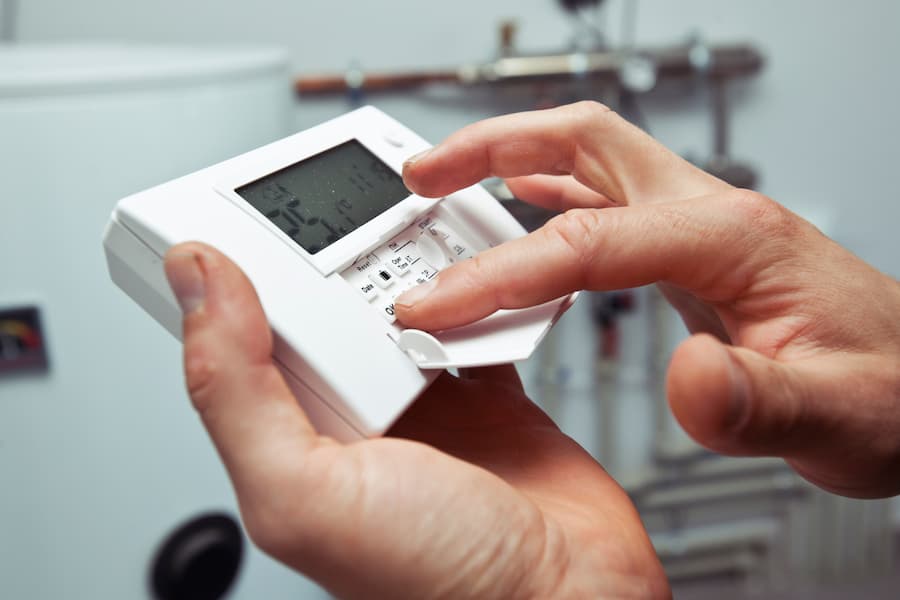 Person checking a digital thermostat